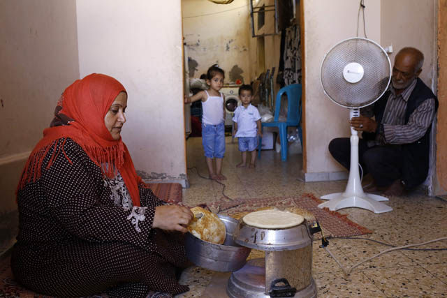 This file photo taken on July 29 shows a Palestinian woman preparing bread during the few hours of electricity supply they receive every day in Gaza City (AFP photo)
